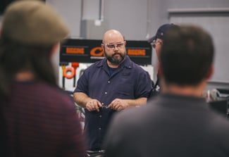 Image of man wearing safety glasses teaching a group of people