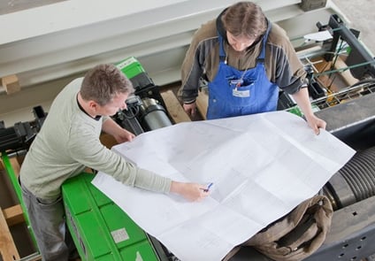 Image of two people working on blueprints