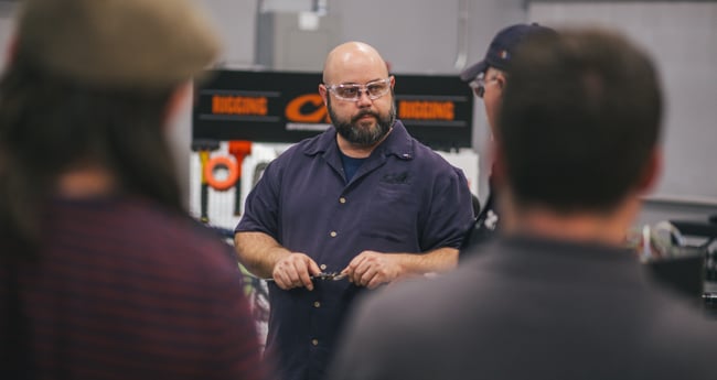 Image of man wearing safety glasses teaching a group of people